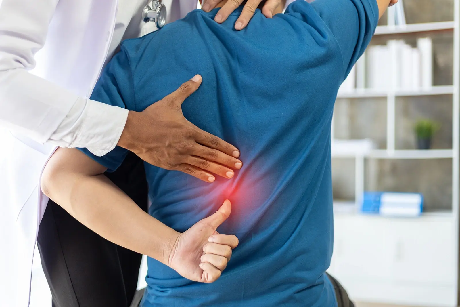 A man visiting a doctor for a back pain diagnosis.