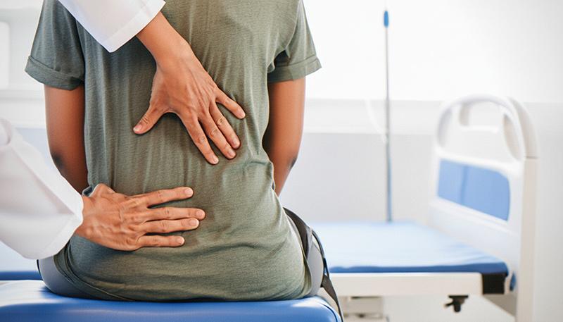 A spine specialist assessing a patient's spine in a clinical setting