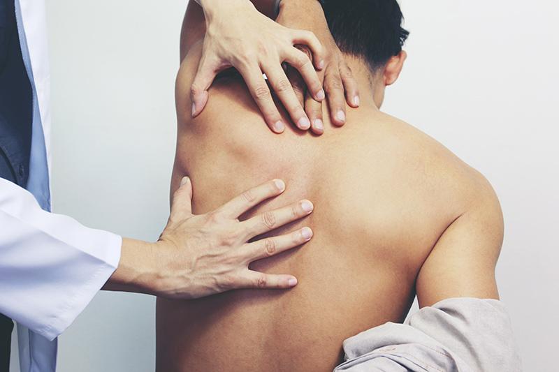 A medical professional assessing a patient's back pain