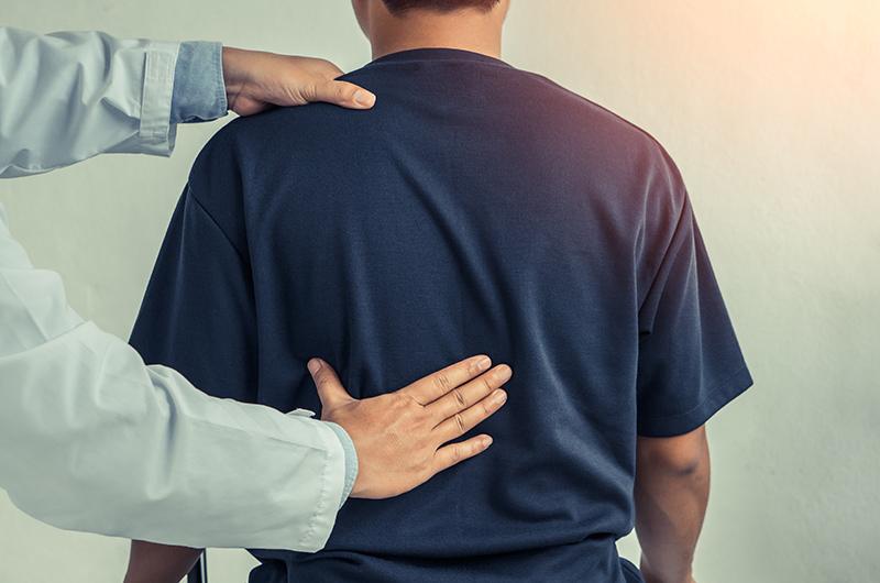 Doctor assessing patient with back pain