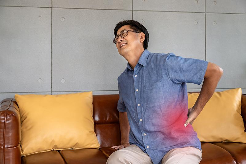 Man experiencing lower back pain due to spinal stenosis.