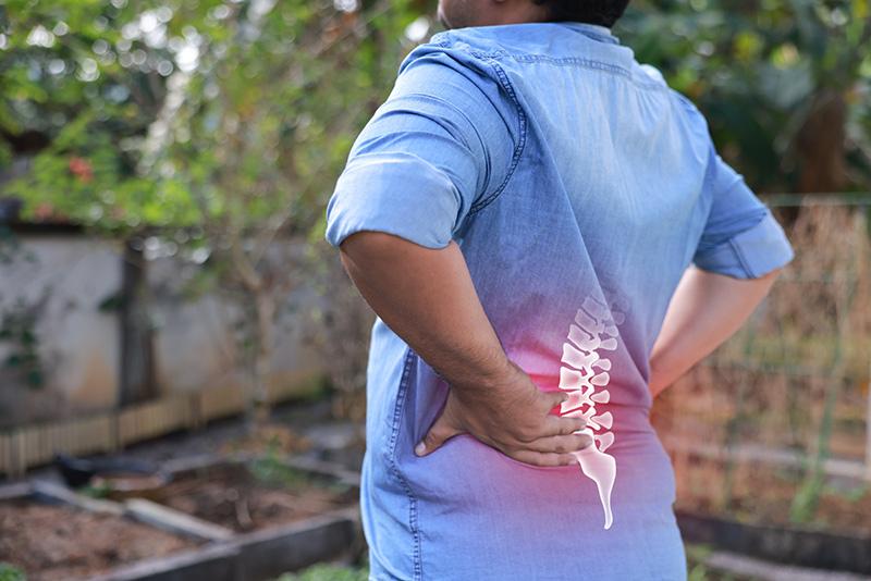 Man suffering from back pain highlighted in red
