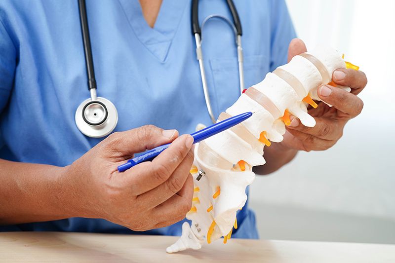 A specialist explaining herniated disc surgery recovery