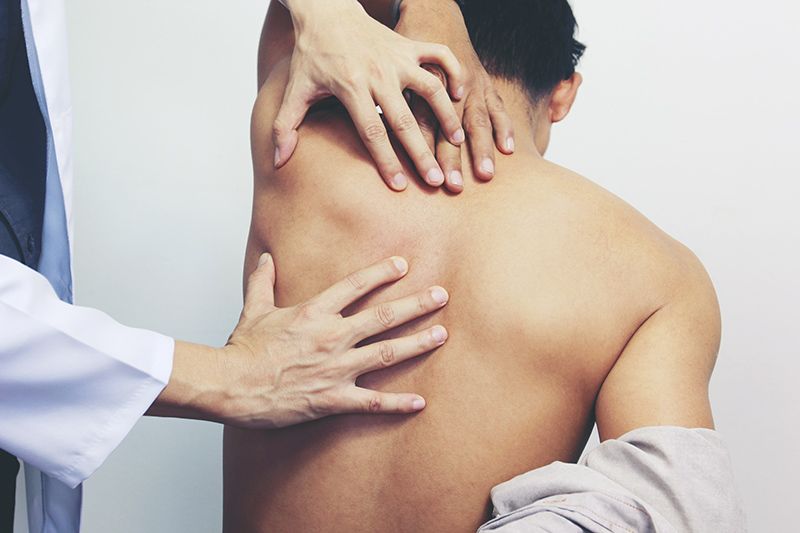 A medical professional assessing a patient's back pain