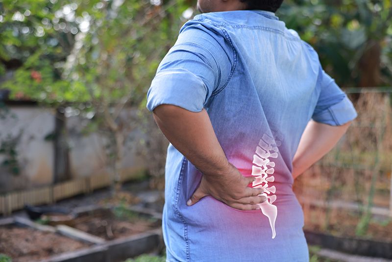 Man suffering from back pain highlighted in red